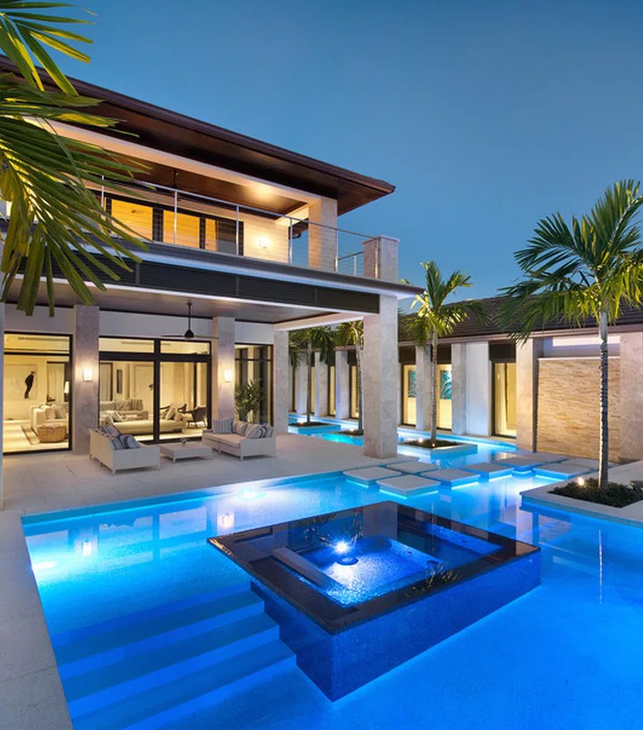 Luxury villa with illuminated infinity pool at night
